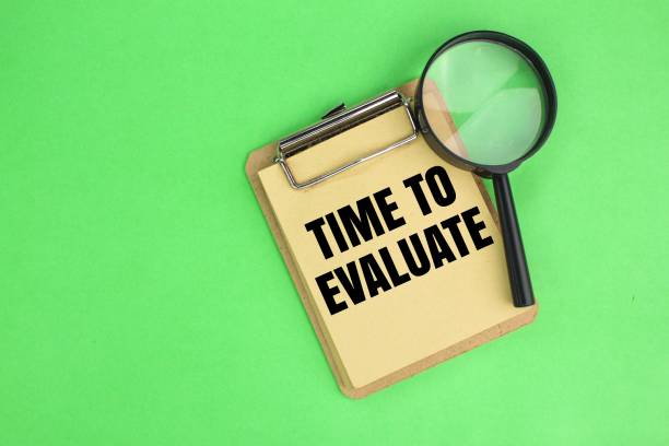 istock magnifying glass and book with the word time for evaluate 2198324268