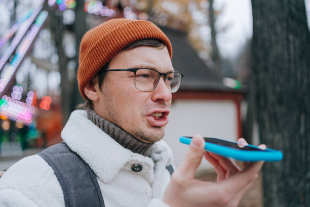 istock Blogger recording voice message on smartphone in amusement park 2198324791