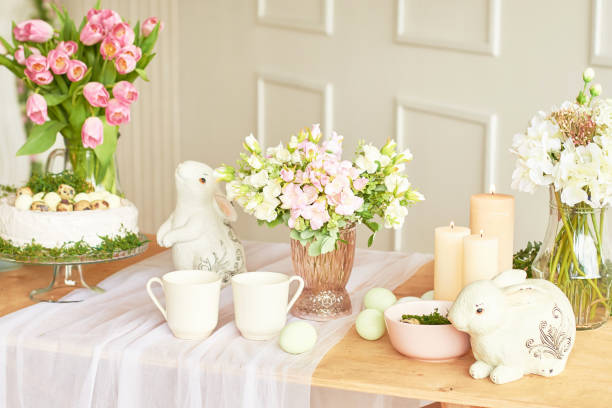 Happy Easter! Holiday Decorations. Beautiful festive Easter table setting with bunny, flowers and eggs. Spring color theme, copy space.Easter Greeting Card Template. Kitchen interier
