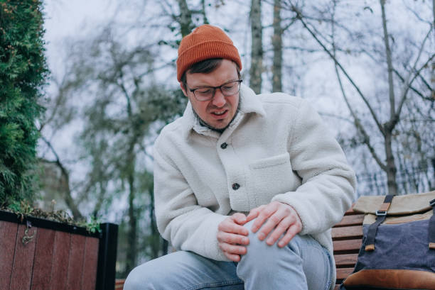 istock Man experiencing knee pain while sitting on bench in park 2198326288