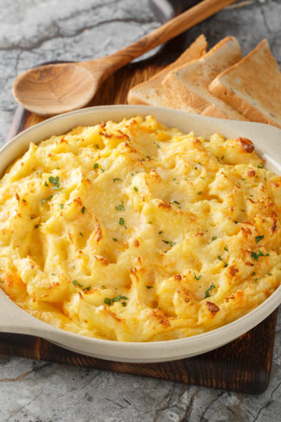 istock Baked Cheesy Mashed Potatoes with parmesan and cheddar closeup on the baking dish. Vertical 2198326782