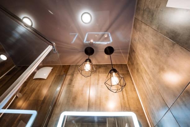 Bottom-up view of a closed bathroom door with a ceiling light on, toilet in an apartment