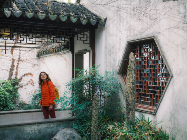 Woman exploring classical Chinese garden in Suzhou, China in autumn