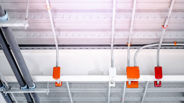 istock Electrical cable conduit with colorful junction box for electric wiring system on the ceiling in modern building. Pipe and fitting equipment for power systems 2198340409