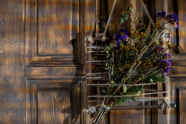 A beautiful rustic display of a variety of dried flowers gracefully hanging on a wooden door, adding warmth and charm