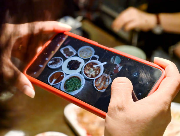 istock female using smart phone shooting food photograph 2198360457
