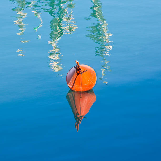 Plastic red bouy on a calm lake isolated on blue background