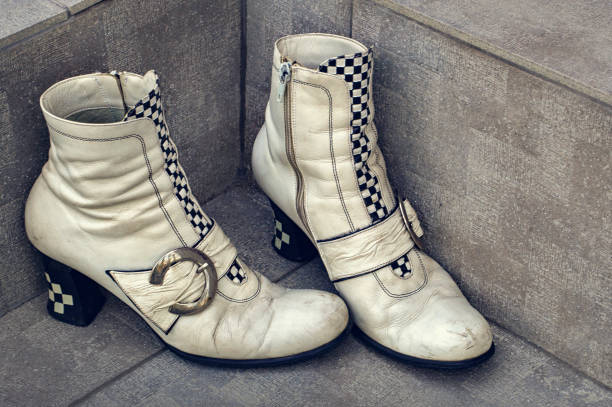 Old boots with buckles on a dirty concrete background