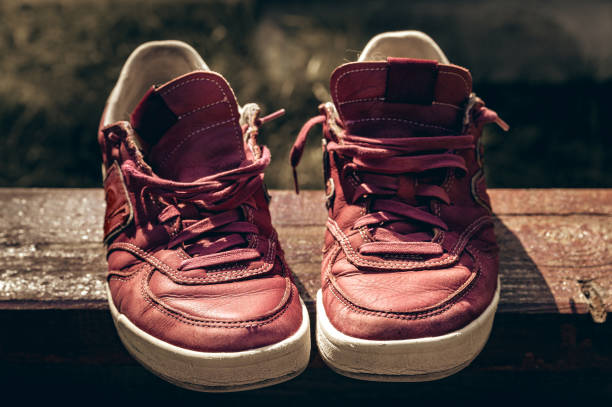 Old maroon sneakers on a wooden abstract