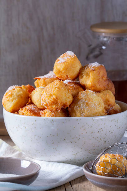istock Curd donuts with sugar served with tea or coffee on a light wooden background. Rustic style. 2198379017
