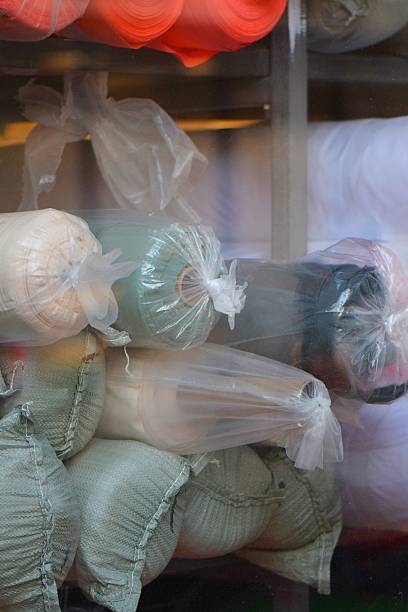 istock Rolls of neutral fabrics displayed outside textile store 2198380110