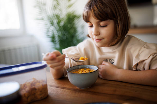 istock Cute little girl eating corn flakes with milk 2198380761