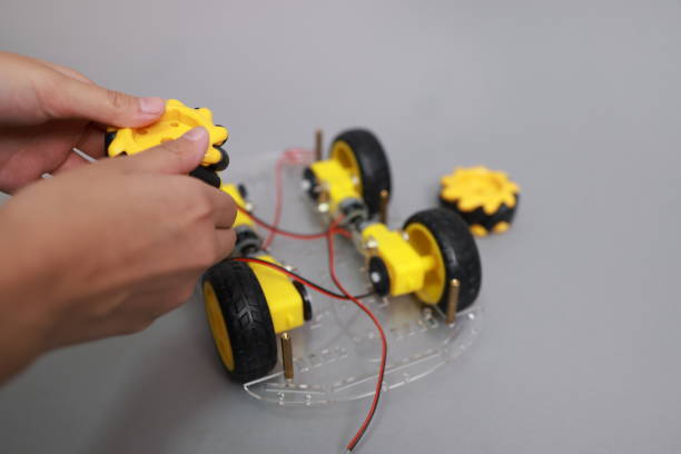 istock Child hand assembly wheel and component of robotic, innovation and technology learning. girl study about robot design and assembly, Technology and Innovation learning class 2198380976