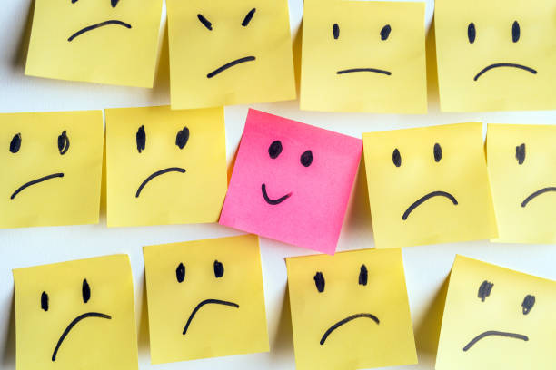 istock Pink Post-It With Smiley Among Yellow Sad Faces Symbolizing Positivity 2198386811