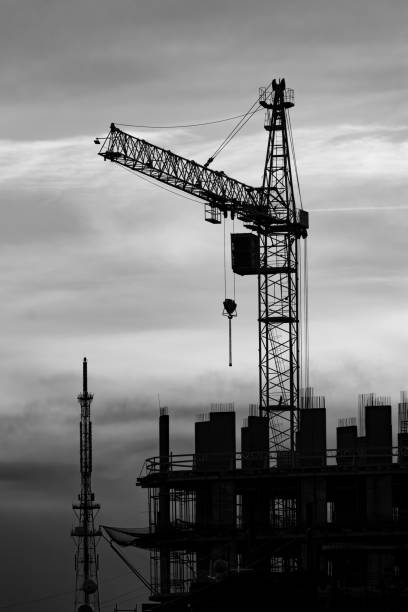 istock construction crane over skyscraper under construction. vertical shot. black and white photo 2198387247