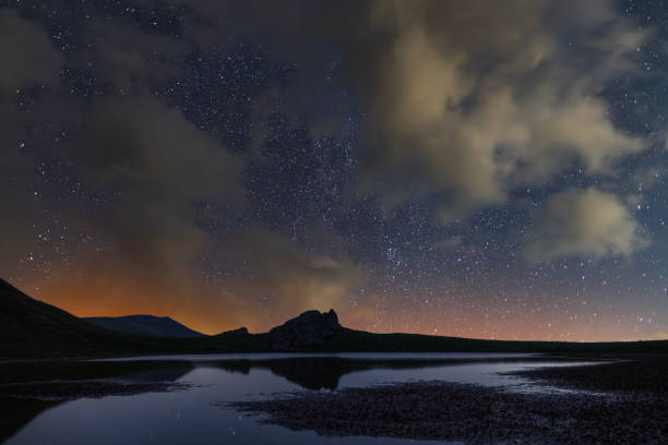 istock Bright Milky Way galaxy over the small  lake and mountains. 2198387484