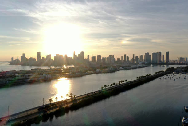 Witness the tranquil beauty of Miami at sunrise. This aerial view captures the city's stunning skyline as it is bathed in the soft morning light, highlighting the calm waters and the vibrant life starting its day along the waterfront.