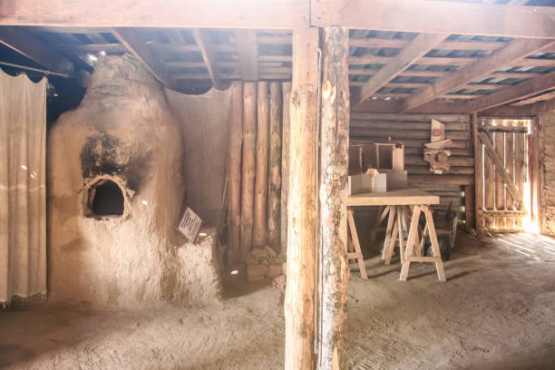 istock ancient dwelling, A dirt room with a wood stove and a table 2198388050