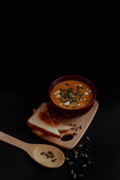 istock Pumpkin soup with toast on a black background 2198388940