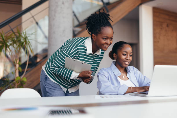 istock Two young black businesswomen collaborating on a project using a laptop 2198392689