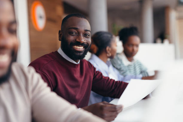 istock Smiling black businessman holding document during a meeting with colleagues 2198392767