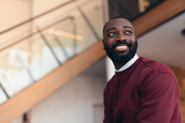 Smiling young manager looking away in modern office building