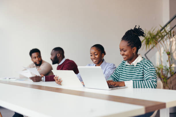 istock Young african professionals working together on laptops and tablets in modern office 2198392987