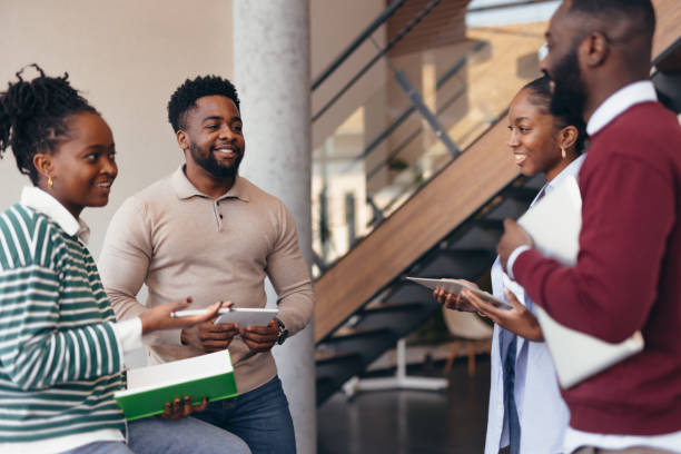 istock Young african professionals discussing using digital tablets and book in modern office 2198393071