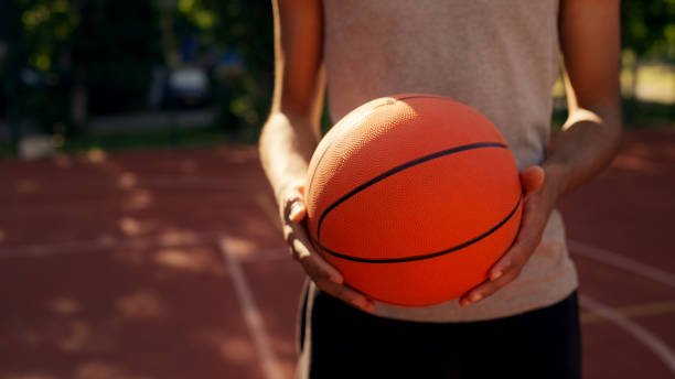 istock Basketball player holds the ball while standing on the court, preparing for training and practice 2198393798