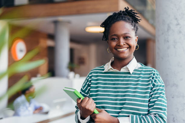 istock Young black female student smiling at the camera in university hall 2198394913