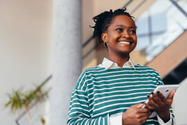 istock Young black female manager smiling and holding tablet in modern office 2198394926