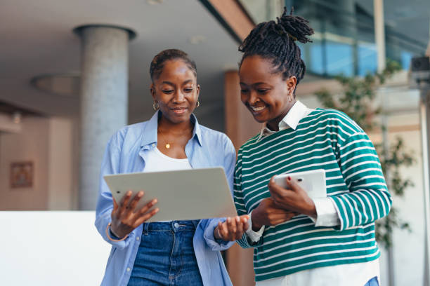 istock Two businesswomen smiling and comparing data on tablet and phone 2198394934