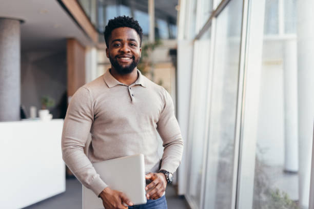 istock Confident young businessman holding laptop in modern office 2198395014