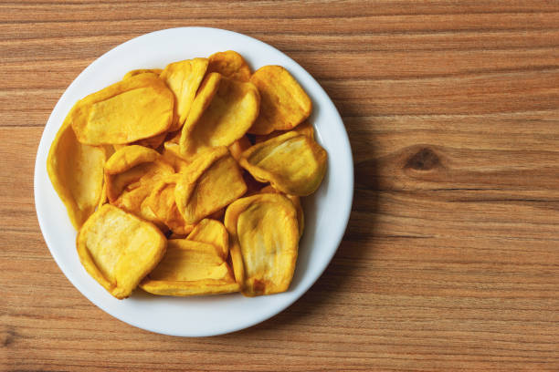 istock Keripik Sukun or Breadfruit Chips is a food made from breadfruit in a plate on a pine table surface 2198395124