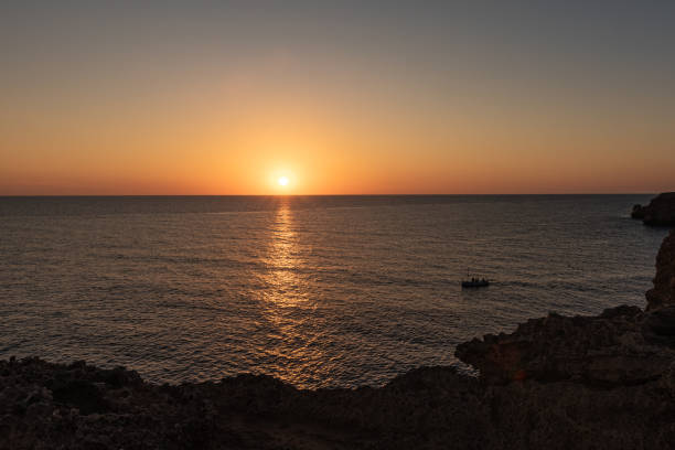 istock A boat serenely sailing on calm waters at dawn or dusk. 2198398826
