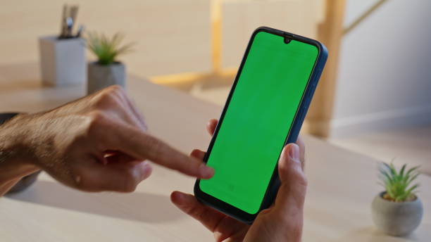 istock Guy choosing purchase chroma key cellphone sitting home workplace closeup. 2198398962