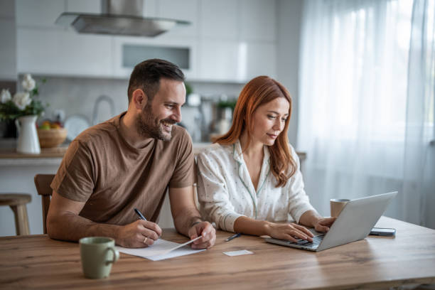 istock Loving couple working together on documents at their home office desk 2198400618