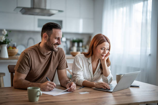 istock Loving couple working together on documents at their home office desk 2198400625