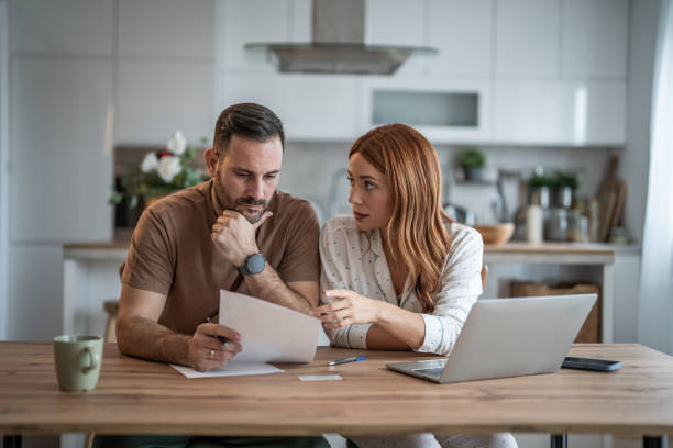 istock Loving couple working together on documents at their home office desk 2198400627