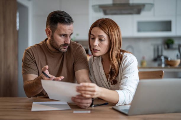 istock Loving couple working together on documents at their home office desk 2198400708