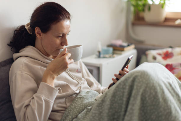 istock Woman suffering from flu at her home and using a mobile phone 2198400810