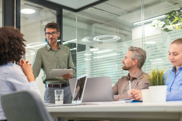 istock Four business professionals using laptop on desk discussing strategy company 2198403329