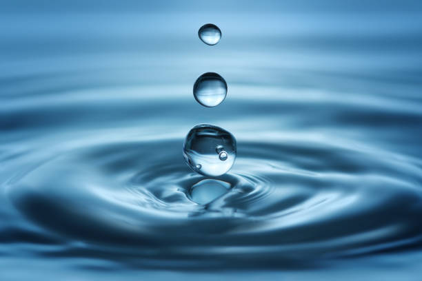 Water drops with ripples and small bubbles trapped stock photo
