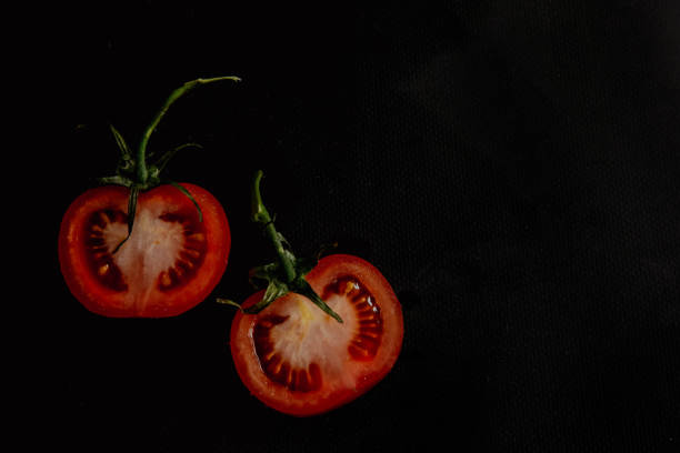 Slices of fresh tomatoes on black background.
