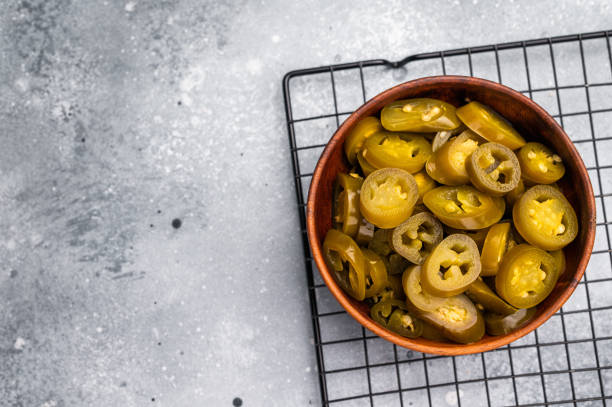 istock Pickled Jalapeno, Marinated Green Mexican pepper Slices. grey background. top view 2198404646