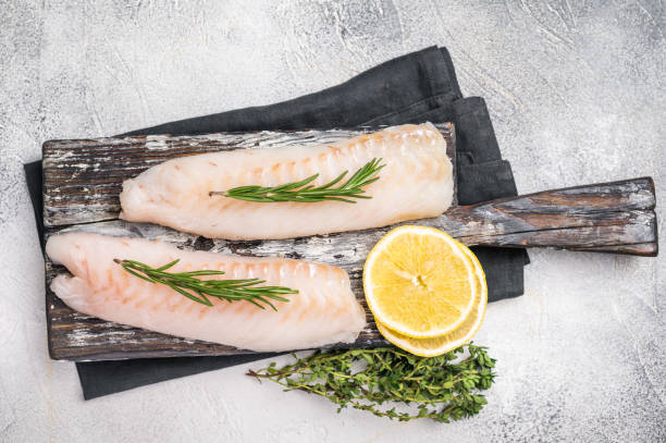 istock Raw cod Loin, white fish fillets without skin on wooden board. white background. top view 2198405748
