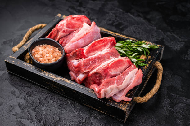 istock Raw Veal Short Rib, fresh beef meat with bone and herbs for cooking . black background. top view 2198407176