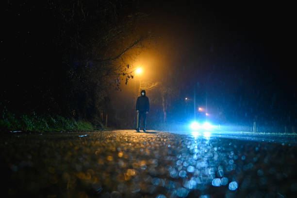 istock Burglar on an empty rainy street at night. 2198423615