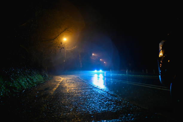 istock Headlight of car on wet dark road. 2198423798