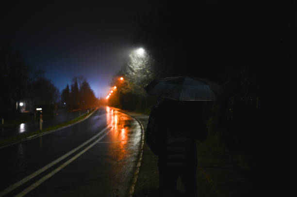 istock Man with umbrella walking on the night street. 2198423859